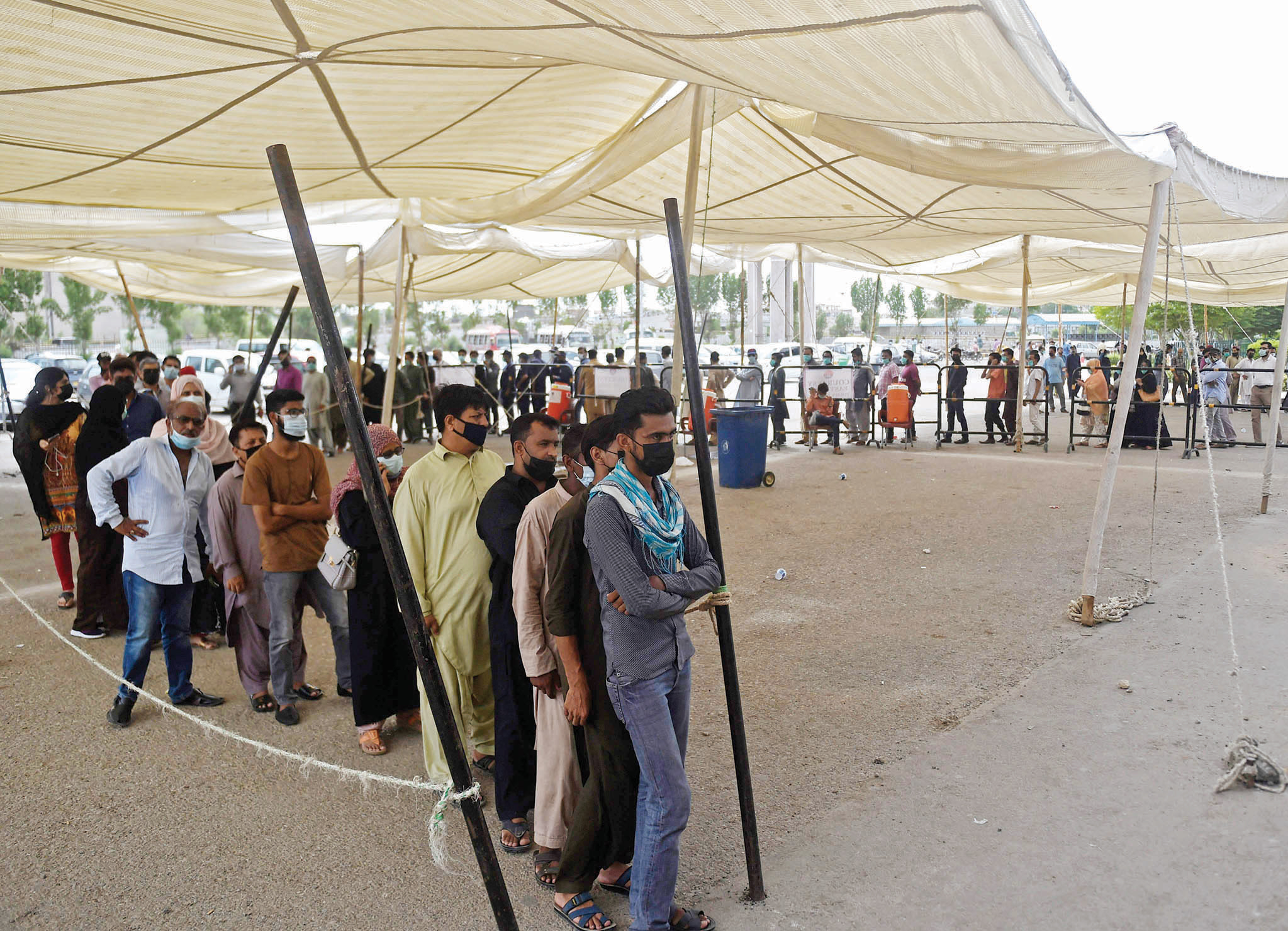 باكستانيون ينتظرون دورهم لتلقي جرعة من لقاح فيروس كورونا في كراتشي
