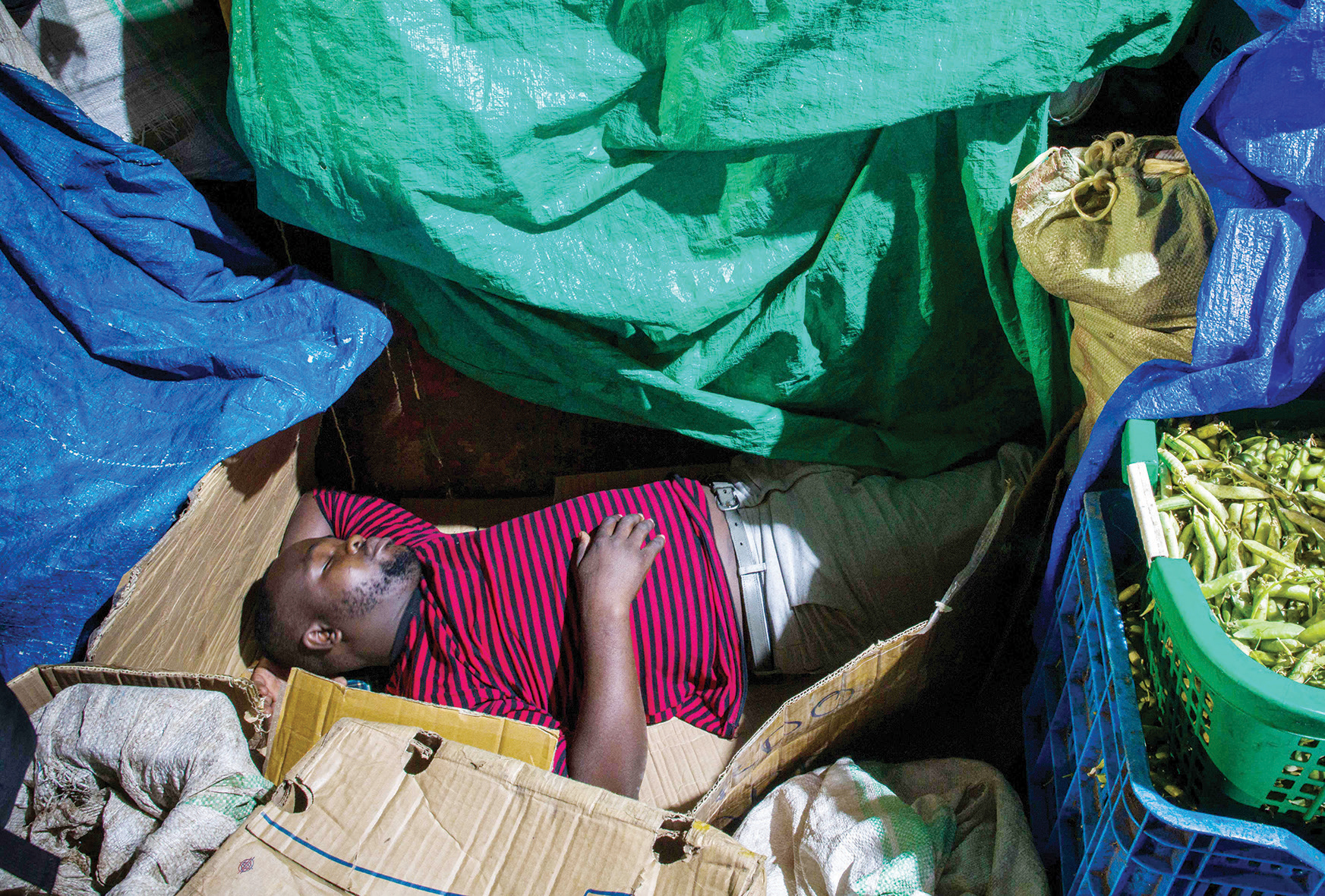 بائع ينام في محله بسوق في أوغندا