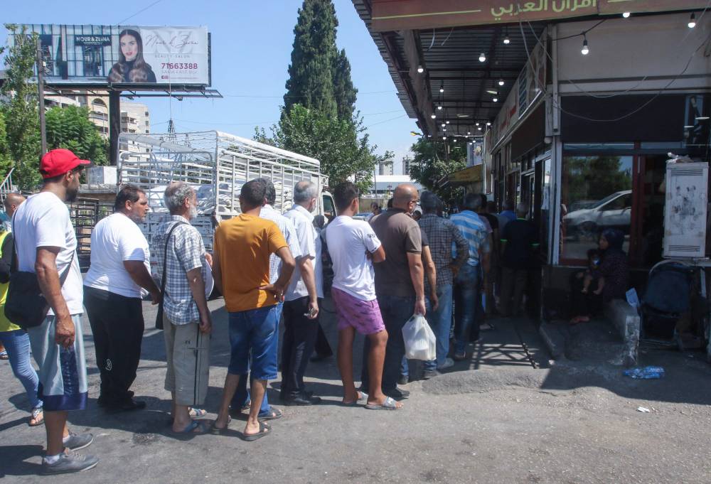 طابور من اللبنانيين للحصول على الخبز أمس أمام مخبز في مدينة صيدا. «الفرنسية»