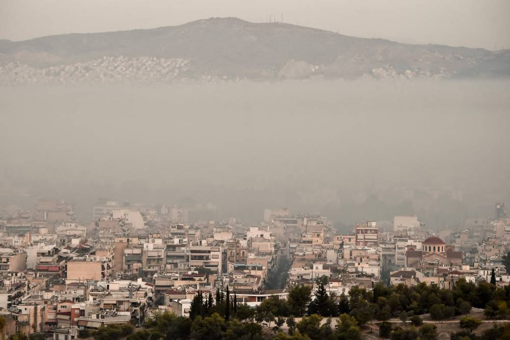 دخان حرائق جبل بارنز يغطي وسط مدينة أثينا اليونانية، حيث يكافح 500 رجل إطفاء وعشرات الطائرات النيران المشتعلة منذ يومين. "الفرنسية"