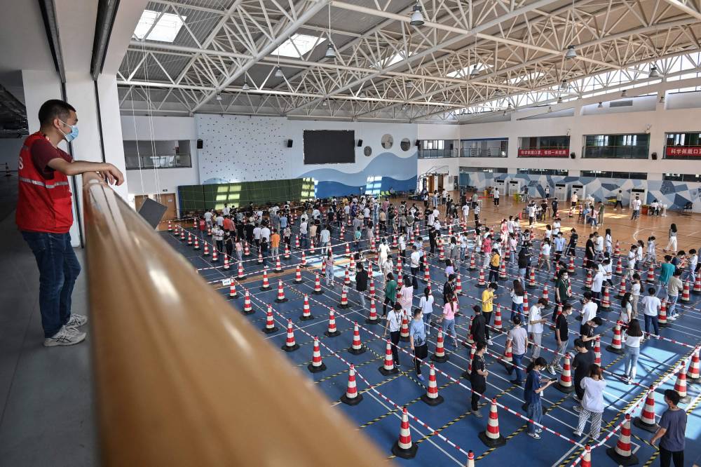 صينيون يصطفون للخضوع لفحص كورونا في مدينة ووهان الصينية. "الفرنسية"