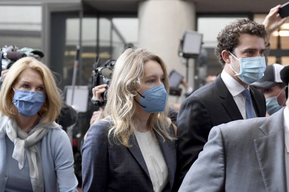 إليزابيث هولمز، في الوسط، تدخل إلى المحكمة الفيدرالية لمحاكمتها في سان خوسيه، كاليفورنيا أمس. "أ ب"