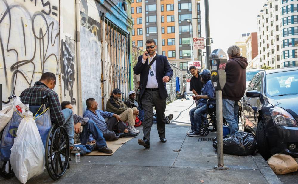 مشردون يجلسون مسترخين على قارعة الطريق في سان فرانسيسكو.