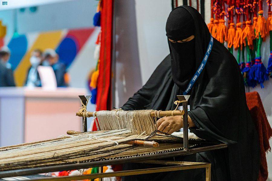 احدى المشاركات تبدع في فن الحياكة.