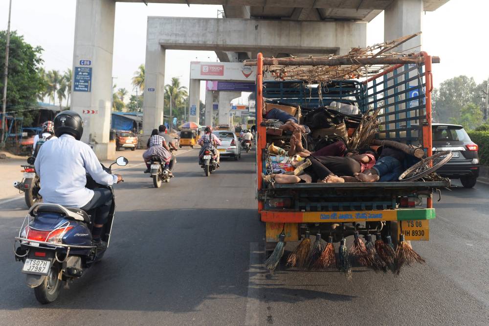 عمال يأخذون قيلولة داخل شاحنة خلال سيرها على أحد طرق حيدر أباد، باكستان. "الفرنسية"