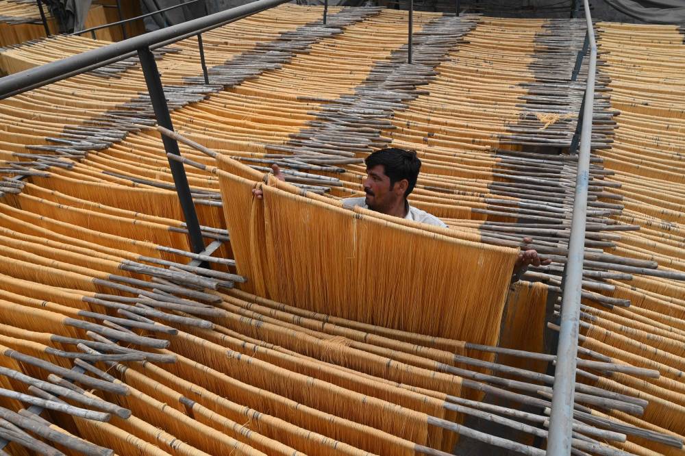 عامل في لاهور يقوم بتجفيف الشعيرية وهي من أطباق الحلوى الرئيسة في رمضان