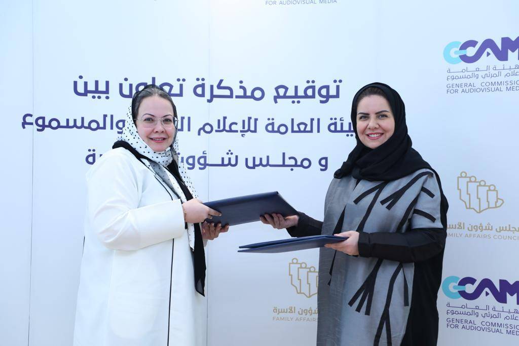 إسراء عسيري وهلا التويجري يتبادلان مذكرات الإتفاقية.