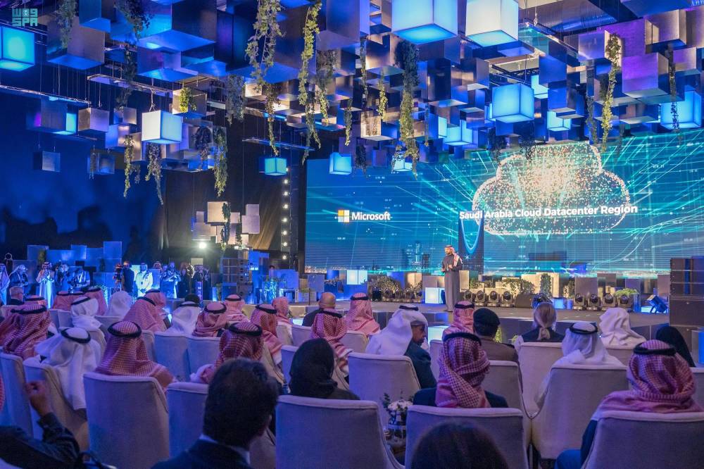 فلسطيني يسير بأكياس حلوى أمام أنقاض مبنى دمرته الغارات الإسرائيلية