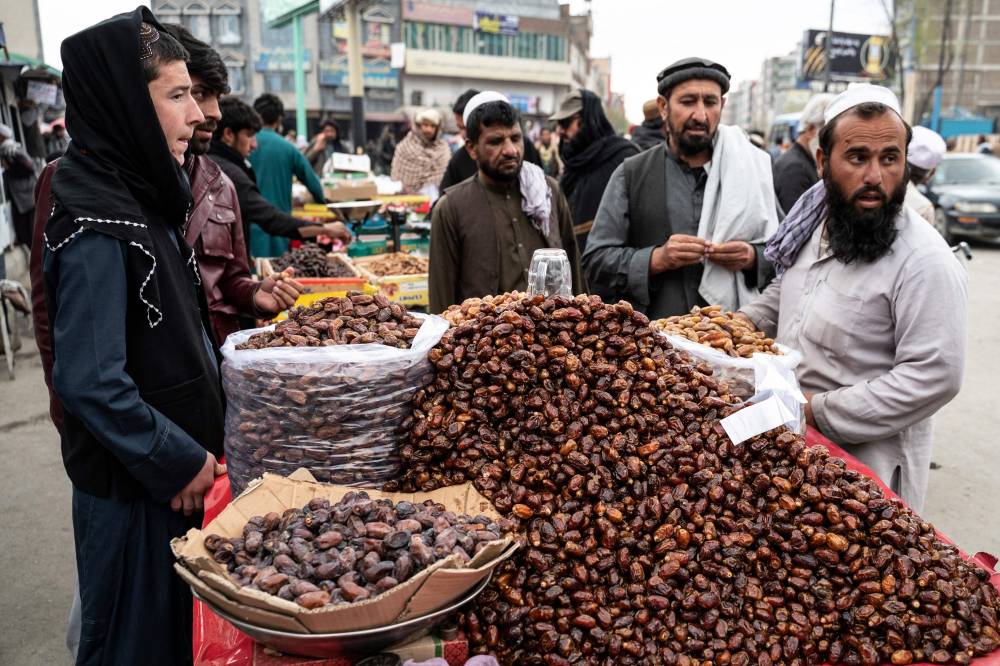 أفغانيون يشترون التمر من إحدى أسواق مدينة كابول استعدادا لصيام شهر رمضان المبارك. "الفرنسية"