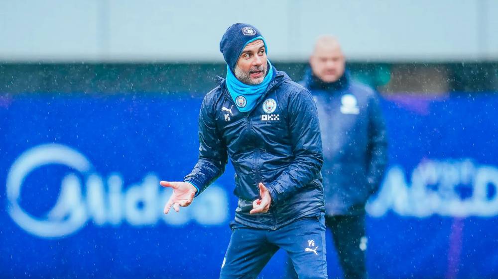 جوارديولا يتابع فريقه رغم الامطار الغزيرة.