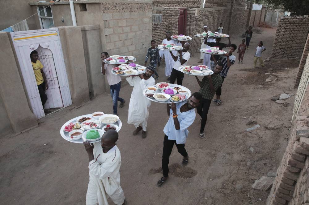 سودانيون يحملون طعام الإفطار في الخرطوم."أ.ب"