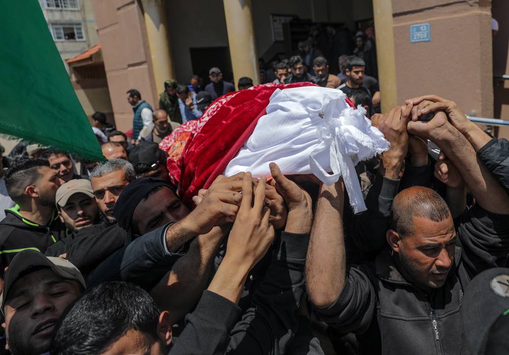 فلسطينيون يشيعون مسنا استشهد نتيجة غارة إسرائيلية في غزة أمس.إ.ب.أ"