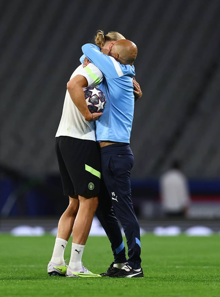 جوارديولا يحتضن هالاند خلال المران. إ.ب.أ