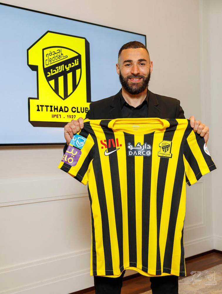 بنزيما يحمل قميص الاتحاد بعد التوقيع.