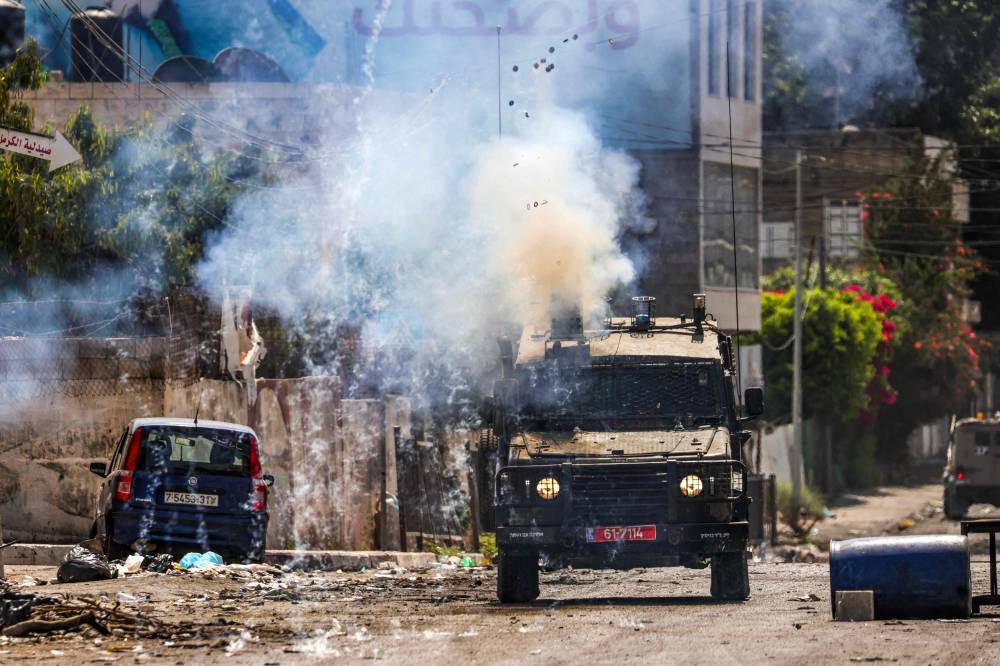 جنود الاحتلال يطلقون قنابل الغاز خلال اقتحام مدينة جنين. «الفرنسية»