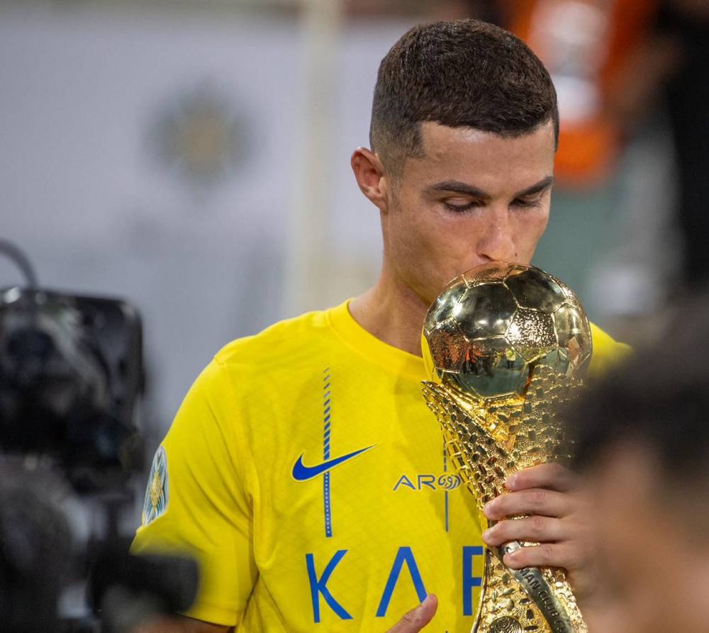 رونالدو يقبل الكأس بعد التتويج أمس.