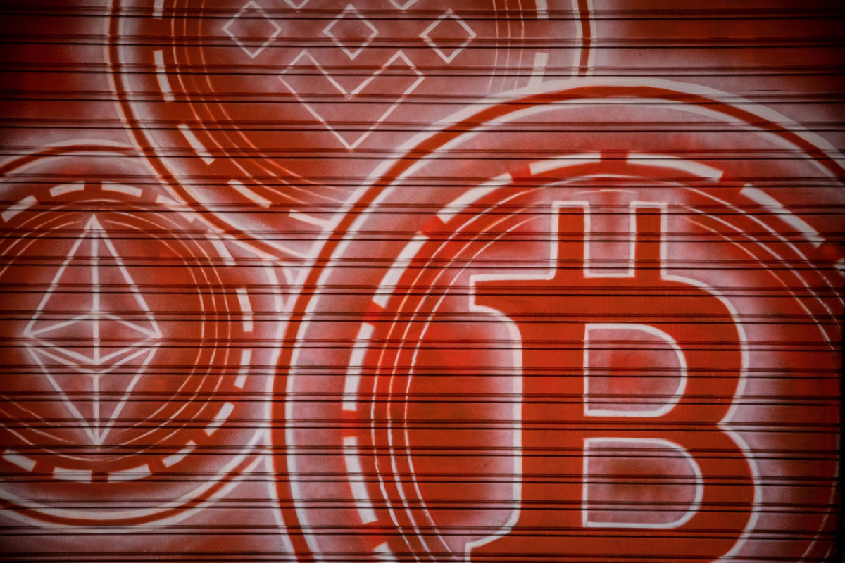 شعارات لعملة "بينانس" في الأعلى و"إيثر" في اليسار و"بتكوين" في المقدمة. "بلومبرغ"