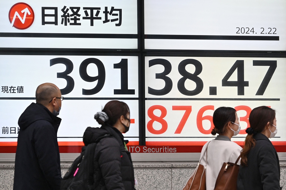 مشاة أمام لوحة تعرض مؤشر نيكاي لبورصة طوكيو أعلى من 39000 نقطة اليوم. الفرنسية