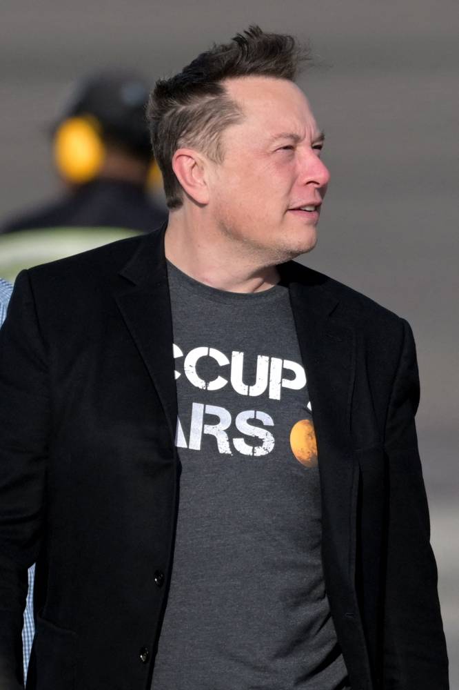 Tech billionaire Elon Musk (R) arrives at Ngurah Rai International airport in Denpasar on Indonesia's Bali island on May 19, 2024. Musk landed in Bali on May 19 to inaugurate satellite unit Starlink expected to provide internet services to the archipelago's remote areas. (Photo by SONNY TUMBELAKA / AFP)