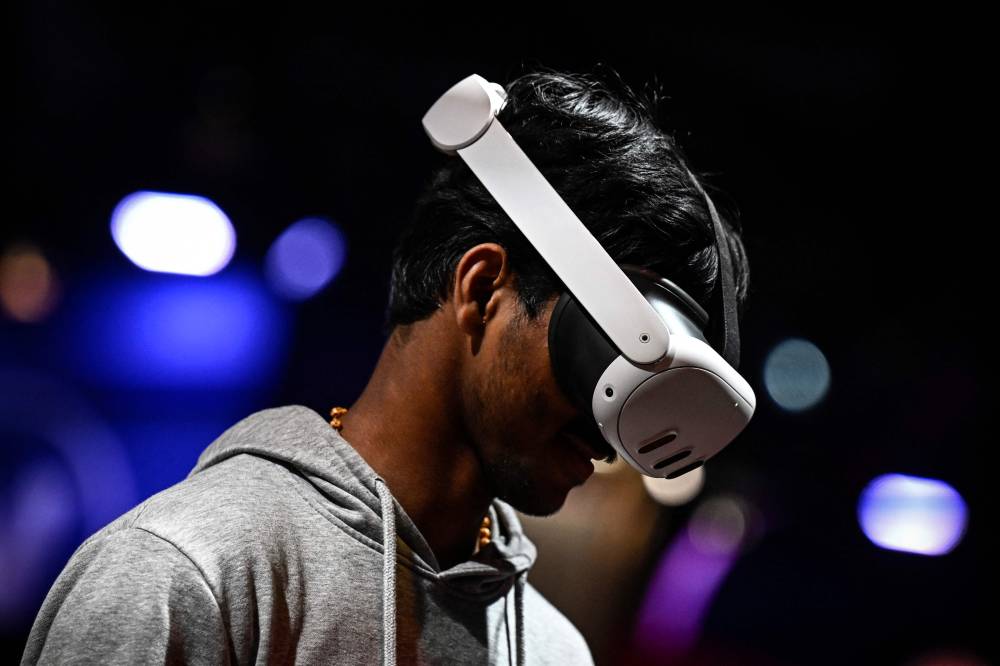 A man tries the Meta Quest 3 mixed reality VR headset during the Vivatech technology startups and innovation fair, at the Porte de Versailles exhibition center in Paris, on May 22, 2024. (Photo by JULIEN DE ROSA / AFP)