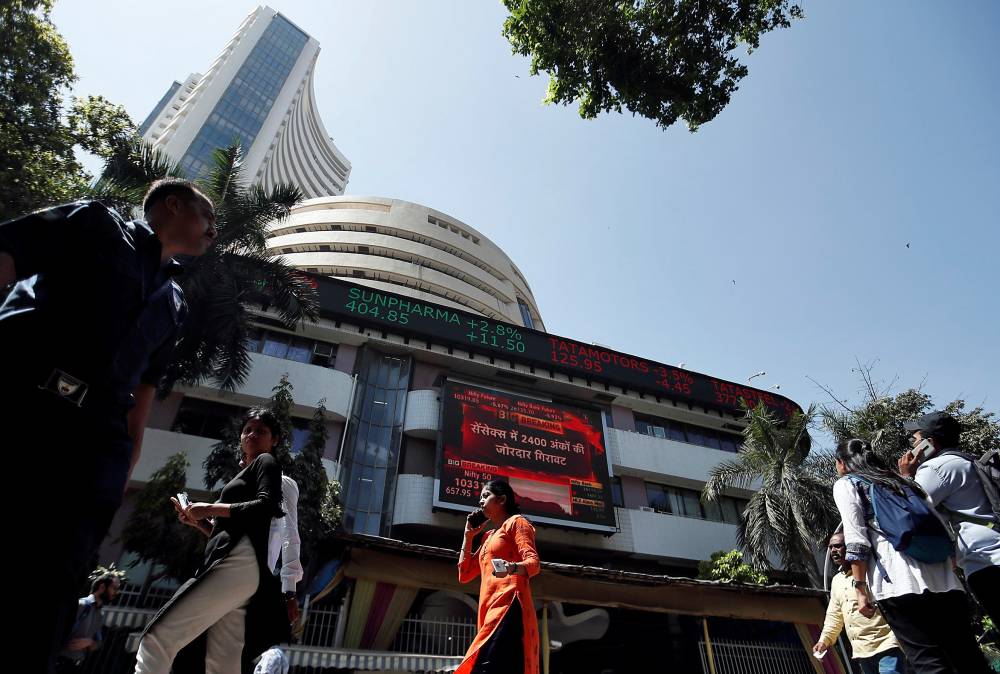 FILE PHOTO:  People walk past the Bombay Stock Exchange (BSE) building in Mumbai, India, March 9, 2020. REUTERS/Francis Mascarenhas/File photo