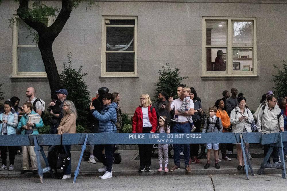 People look on behind a police barricade as the motorcade with US President Joe Biden passes by in the Upper East Side in New York, New York on September 25, 2024. During the UN General Assembly (UNGA) the streets of New York turn into a maze of barricades and closed streets as world leaders descend on the city and street closures from motorcades cause an inconvenience for residents and an spectacle for tourists at the same time. (Photo by ANDREW CABALLERO-REYNOLDS / AFP)