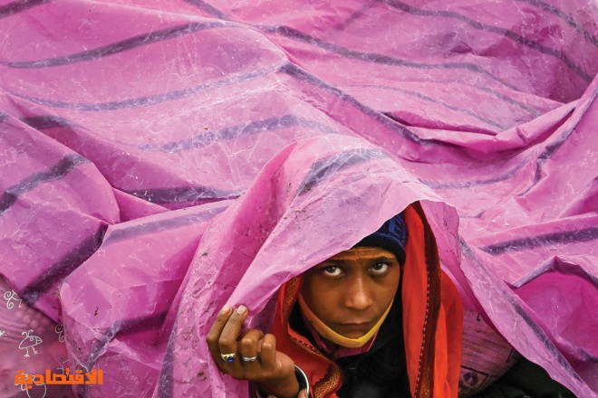 صبي يحتمي بأكياس بلاستيكية من المطر في جزيرة ساجار الهندية 