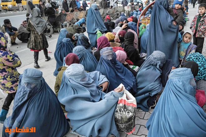 نساء وأطفال ينتظرون توزيع خبز مجاني أمام مخبز في العاصمة الأفغانية