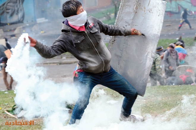 متظاهر يعيد عبوة غاز مسيل للدموع خلال اشتباكات مع الشرطة في الإكوادور