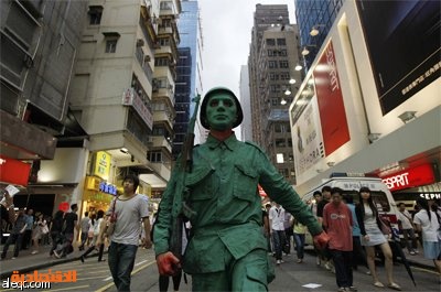 رجل مصبوغ باللون الأخضر يرتدي زي جيش التحرير الشعبي الصيني في ميدان تيانانمين احتفالا بالذكرى السنوية الـ 20 لحملة تيانانمن في ه