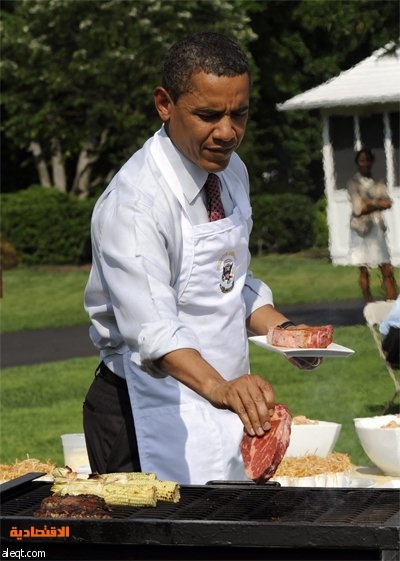 الرئيس الأمريكي باراك أوباما يشوي شريحة لحم أثناء استضافته لطلاب المدارس المحلية في الحديقة الجنوبية للبيت الأبيض في واشنطن.