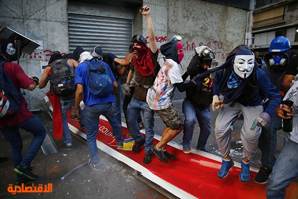 قصة مصورة : محتجون يحرقون دمى للرئيس في فنزويلا