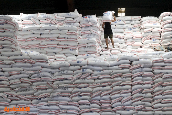 عامل يأخذ استراحة فوق أكياس من الأرز داخل مستودع للهيئة الوطنية للأغذية في الفلبين