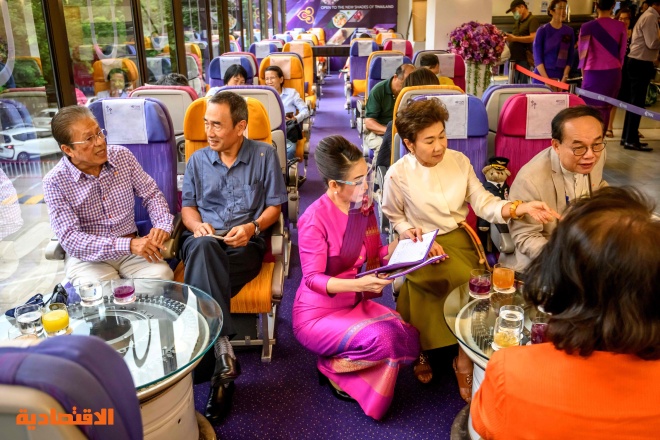  مضيفة طيران تابعة للخطوط التايلاندية تقدم الوجبات في مطعم على طراز طائرة في مقر الشركة  