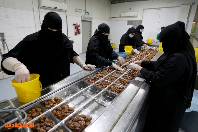 سعوديات يعملن على خط إنتاج مصنع لتعبئة التمور في الأحساء