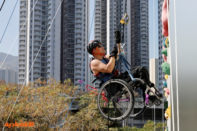 بكرسي متحرك وشلل نصفي .. رمز المثابرة في هونج كونج يتسلق ناطحة سحاب