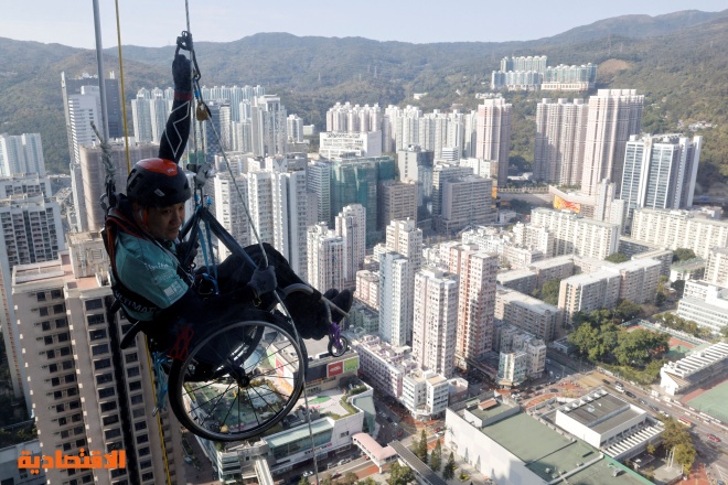 بكرسي متحرك وشلل نصفي .. رمز المثابرة في هونج كونج يتسلق ناطحة سحاب