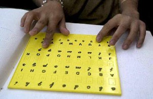 طالب كفيف يقوم بالقراءة عن طريق لوحة المخترع لويس برايل والتي يمكن من خلالها مساعدة المكفوفين على القراءة عن طريق تمرير الاصابع 
