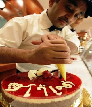 خباز يزين الكعكة بـ"شكرا يا أمي" في محل حلويات في الرياض بمناسبة يوم الأم.