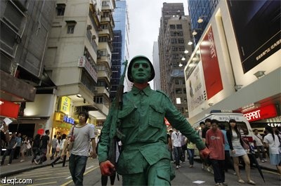 رجل مصبوغ باللون الأخضر يرتدي زي جيش التحرير الشعبي الصيني في ميدان تيانانمين احتفالا بالذكرى السنوية الـ 20 لحملة تيانانمن في ه