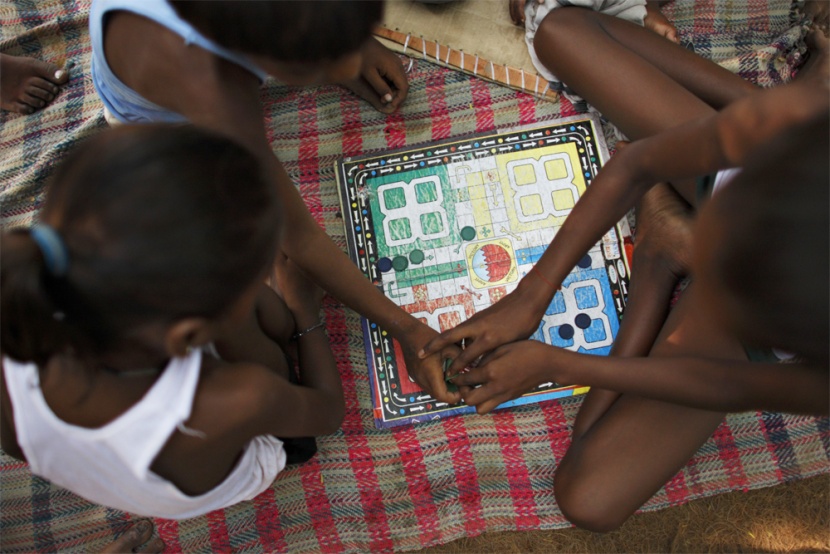 أطفال يتسلون بـ"لعبة الطاولة – Board game"  في أحد الأحياء الفقيرة في نيودلهي.