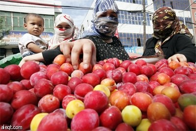 رجل أغواري يشتري العنب في كشك في أحد شوارع مدينة اورومتشى غرب الصين التي تشهد اضطرابات عرقية.