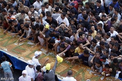 طهاه فلسطينيون يعدون أكبر "كنافة" في العالم في مدينة نابلس ويبلغ وزنها 1.765  كلغ (3٬891 رطل) بطول 74 مترا (243 قدما) وسيطالبون 