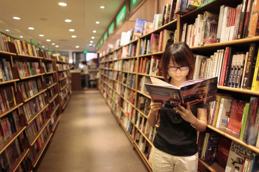 إمراة تقرأ أحد الكتب المعروضة في مكتب شانغهاى حيث  تحضر  الصين استيراد الأفلام والكتب