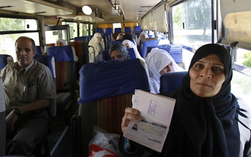 سيدة فلسطينية تبين حصولها على تأشيرة الدخول إلى السعودية لأداء مناسك العمرة وهي تنتظر في حافلة متوجهة إلى مصر عبر معبر رفح الحدو