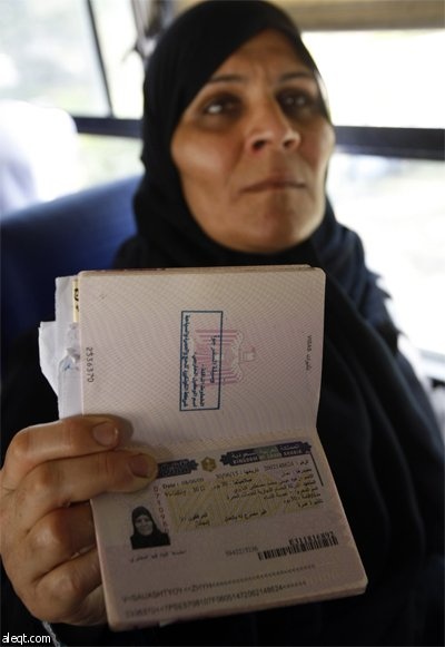 سيدة فلسطينية تبين حصولها على تأشيرة الدخول إلى السعودية لأداء مناسك العمرة وهي تنتظر في حافلة متوجهة إلى مصر عبر معبر رفح الحدو