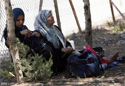سيدة فلسطينية تبين حصولها على تأشيرة الدخول إلى السعودية لأداء مناسك العمرة وهي تنتظر في حافلة متوجهة إلى مصر عبر معبر رفح الحدو