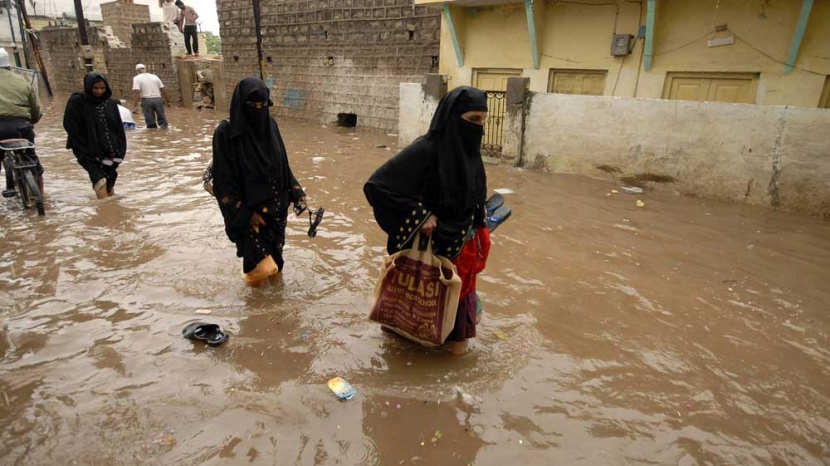 هنديات يحاولن شق طريقهن بعد هطول الأمطار الموسمية