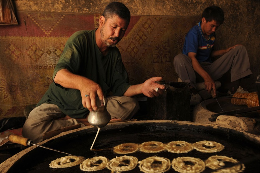 أفغاني يعد الحلوى الخاصة بشهر رمضان المبارك في يومه الأول في كابول.