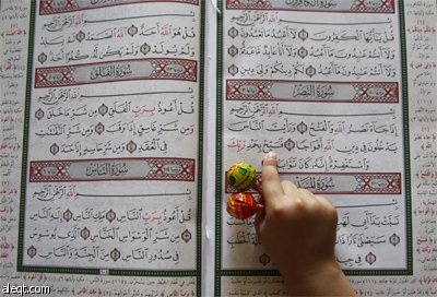 فتاة فلسطينية تقرأ القرآن الكريم في مسجد في مدينة نابلس في اليوم الأول من أيام شهر رمضان المبارك.